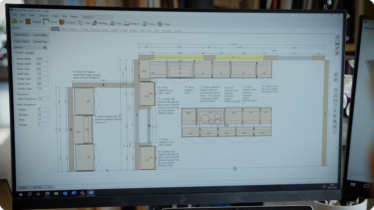 A computer screen displaying a detailed kitchen design layout with cabinets