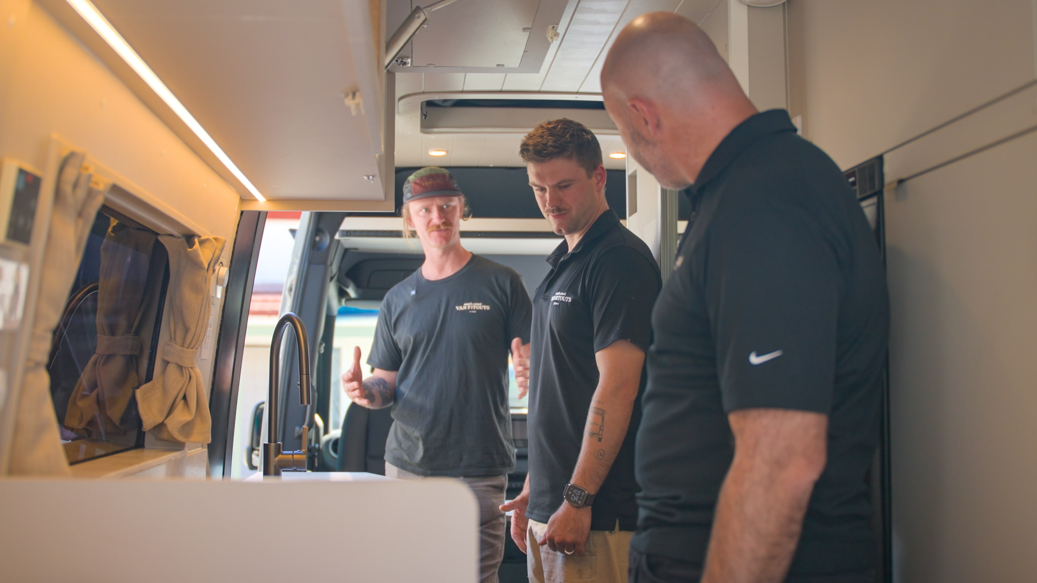 Three men standing inside a van