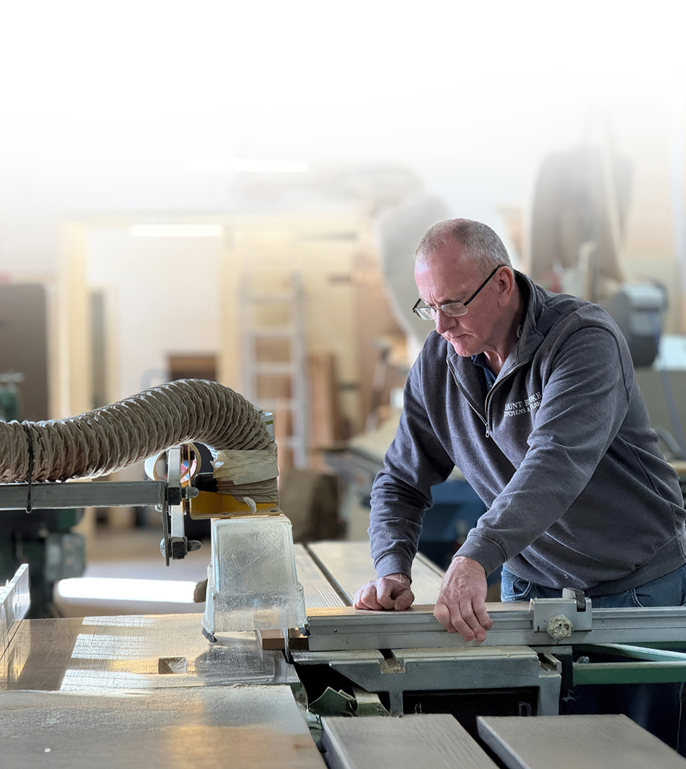 The man is working on a sawing machine