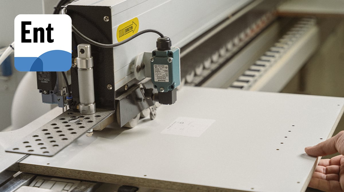 A person operates a machine to cut a sheet of paper