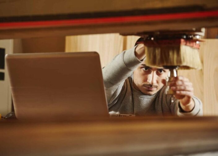 Man sets the cutter in chuck for cutting wood. Machine with computer numerical control.